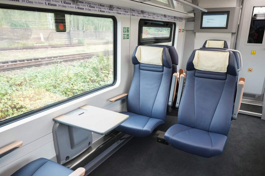 Das Foto zeigt den Innenraum der 1. Klasse eines Mireo-Zugs mit Zweier-Sitz mit Kopflehnenbezug, Armlehnen und Tisch