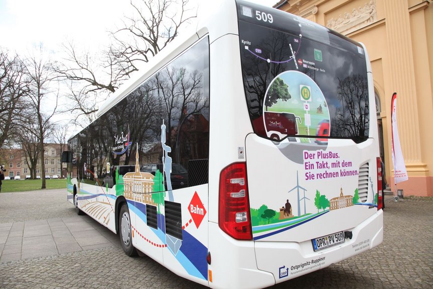 Das Heck des PlusBus Ruppiner Seenland mit dem Slogan "Der PlusBus. Ein Takt, mit dem Sie rechnen können"