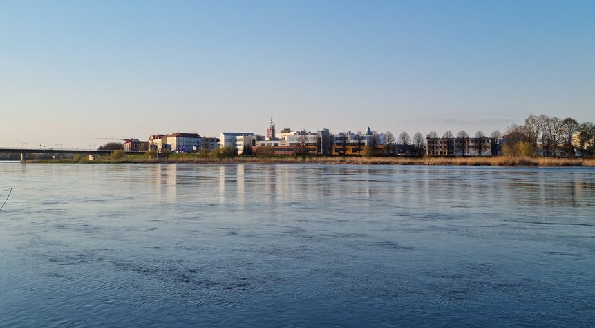 Stadt Słubice fotografiert aus der deutschen Seite ist im Hintergrund zu sehen. Im Vordergrund der Grenzfluss Oder.