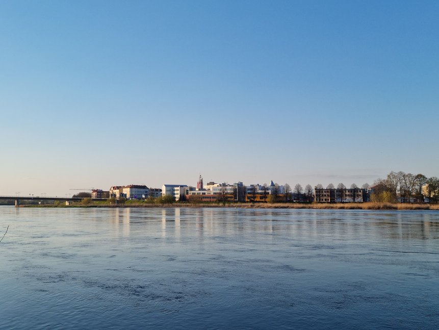 Stadt Słubice fotografiert aus der deutschen Seite ist im Hintergrund zu sehen. Im Vordergrund der Grenzfluss Oder.