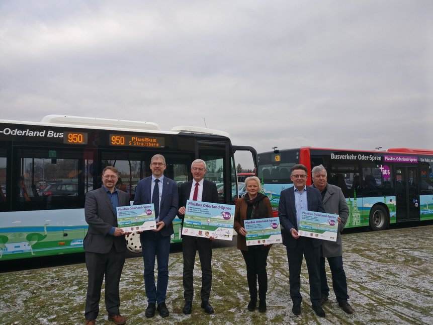 Bild zeigt Pressefoto mit Pressetafeln vor beklebten Bussen