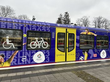 Ein S-Bahn-Zug ist mit dem Special Olympics World Games Motiv beklebt.