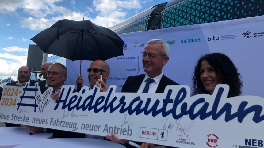 Das Foto zeigt Personen bei der Vertragsunterzeichnung NEB Heidekrautbahn