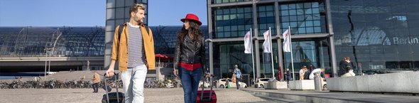 Paar mit Rollkoffern vor Berliner Hauptbahnhof
