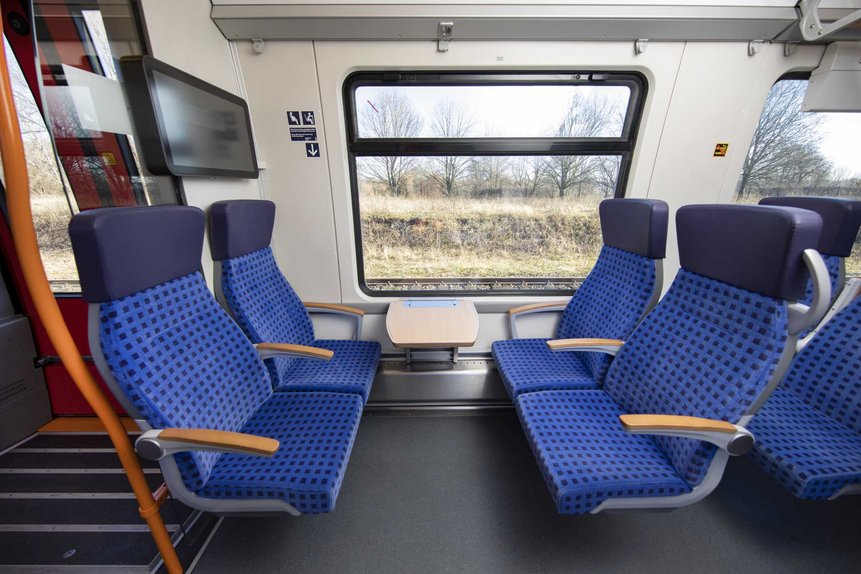 Das Foto zeigt eine Vierer-Sitzgruppe in der 2. Wagenklasse in einem modernisierten Talent2-Zug.