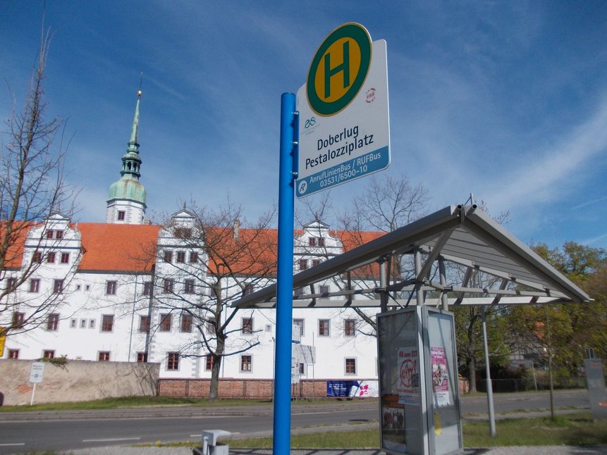 Foto vom Schloss und davor liegender Haltestelle in Doberlug