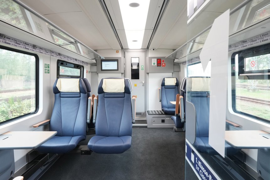 Das Foto zeigt die 1. Klasse in einem Mireo-Zug: Zweier-Sitz mit Tisch, Kopflehnenbezug und Armlehnen