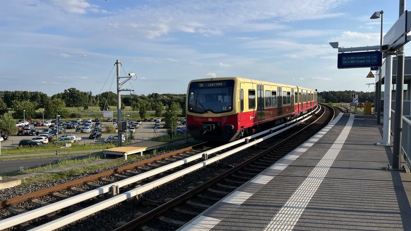 Blick auf eine S9 Richtung Spandau vorbeifahrend am Bahnhof Waßmannsdorf