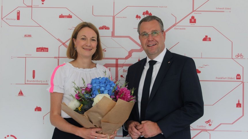 Herr Genilke überreicht Fr. Dr. Meike Niedbal einen Blumenstrauß.