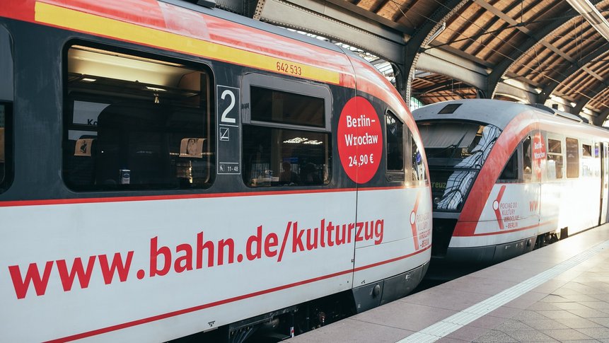 Zweiteiliger rot-weißer Kulturzug steht am Bahnsteig in Breslau.