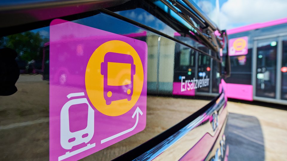 Das Foto zeigt das Piktogramm für den Ersatzverkehr in Nahaufnahme, im Hintergrund einen Bus
