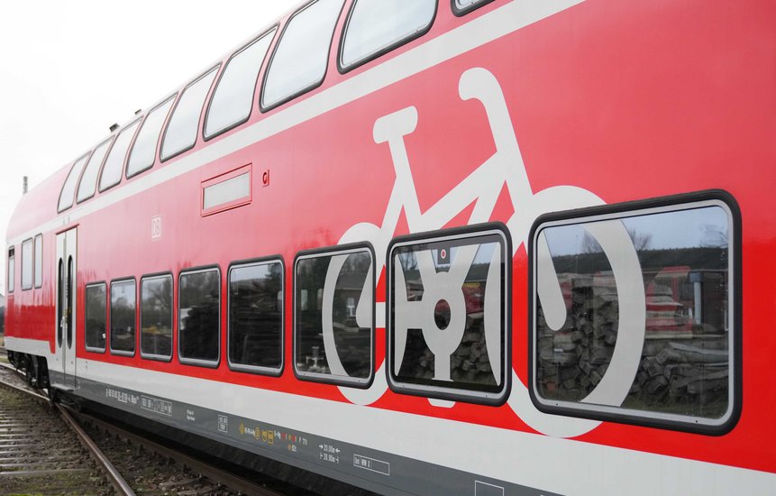 Das Foto zeigt ein großes weißes Fahrrad-Piktogramm am Wagen eines modernisierten Doppelstockwagens.