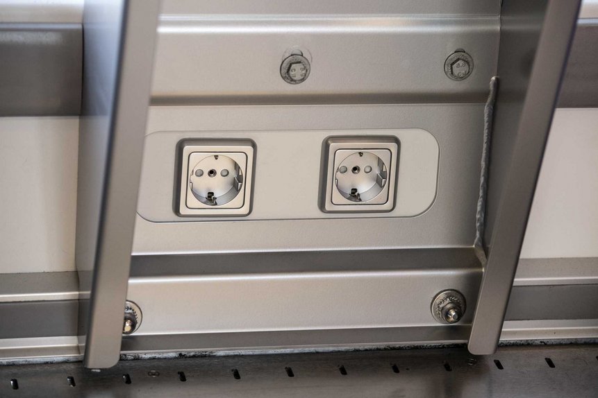 Das Foto zeigt Steckdosen, die sich neu unter den Tischen bei den Vierer-Sitzgruppen in den modernisierten Talent2-Zügen befinden.