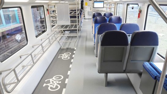 Das Foto zeigt das Unterdeck eines modernisierten Doppelstockwagens mit Fahrradabstellbereichen und Sitzplätzen.