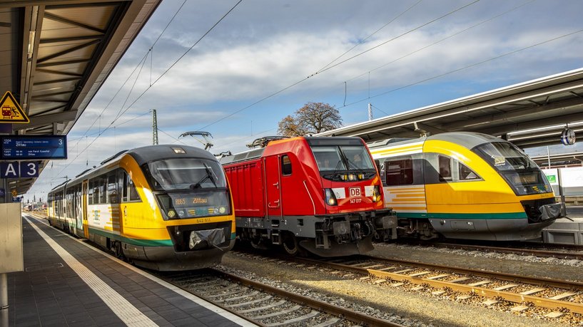 Foto von drei Regionalverkehrszügen am Bahnhof