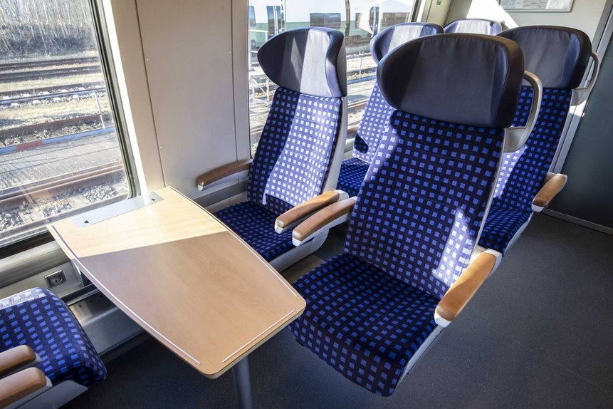 Das Foto zeigt Sitze und einen Tisch in der 1. Wagenklasse eines modernisierten Talent2-Zugs.