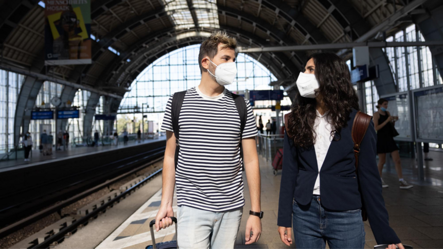 Mann und Frau mit FFP2-Maske am Bahnhof