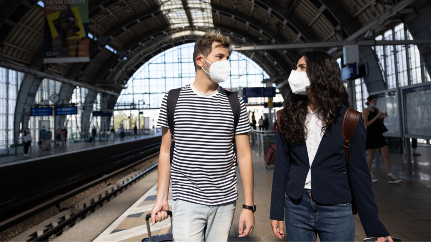 Maskenpflicht im ÖPNV Mann und Frau mit FFP2-Maske am Bahnhof